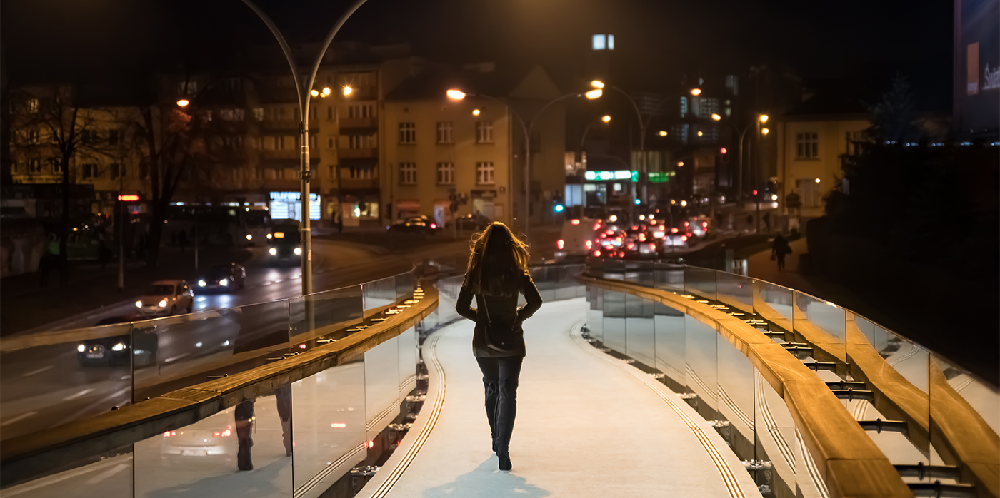 woman walking along path at night