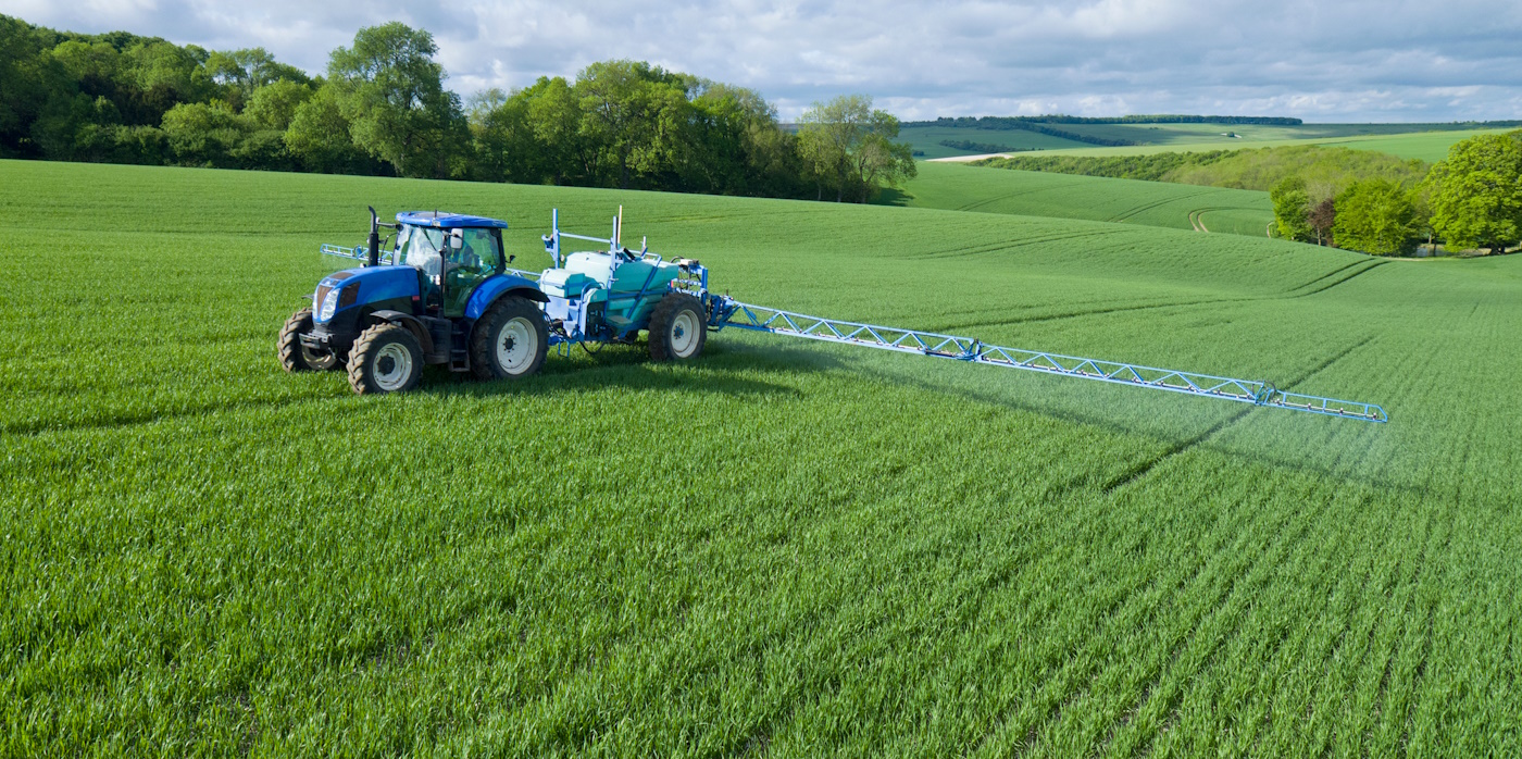 Tractor spraying pesticide on fields